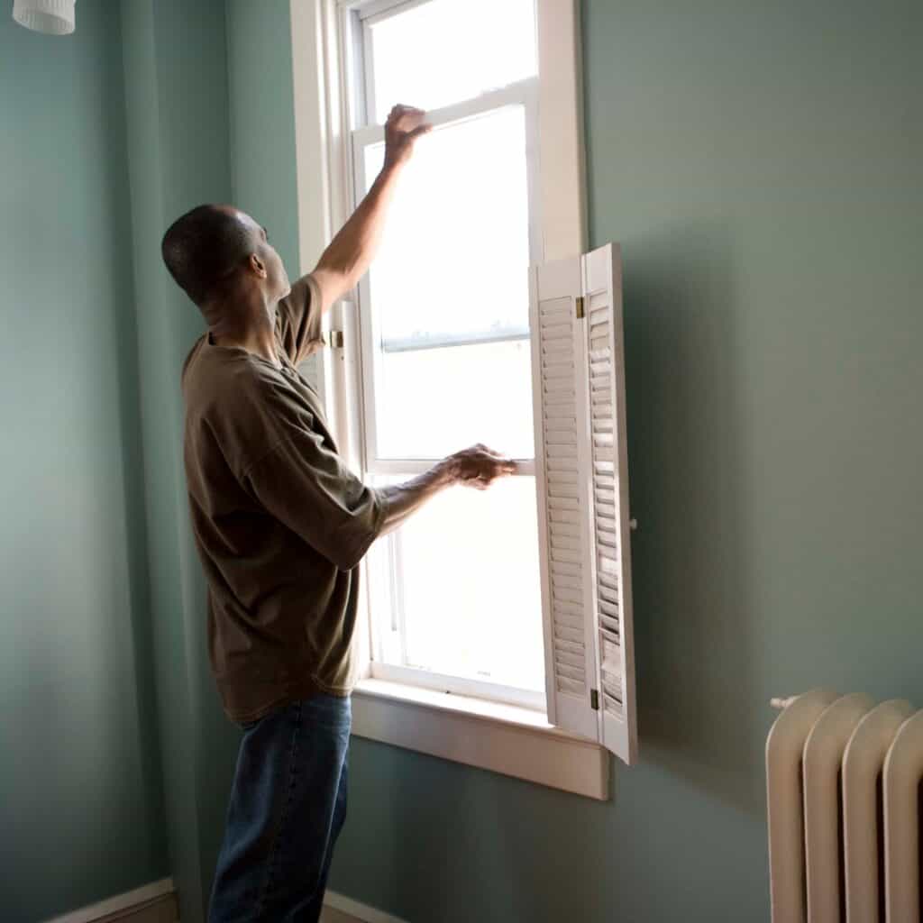 Professional inspecting home ventilation system during Ventilation Assessment Services for improved thermal comfort.